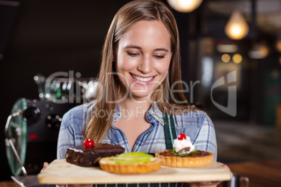 Pretty barista holding desserts