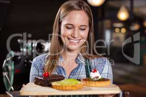 Pretty barista holding desserts