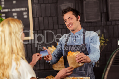 Portrait of a smiling woman paying with credit card