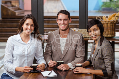 Smiling friends holding a cup of coffee Smiling friends holding a cup of coffee