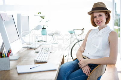 smiling hipster businesswoman sitting at her desk