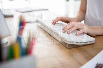 womans hands typing on  a keyboard