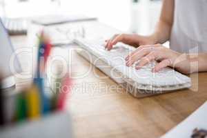 womans hands typing on  a keyboard