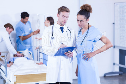 Doctors writing on clipboard