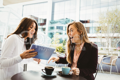 Surprised friends looking at tablet