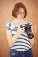 beautiful hipster woman looking at pictures on a digital camera