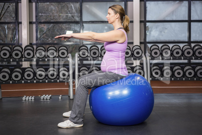 Determined woman exercising on fitness ball