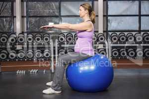 Determined woman exercising on fitness ball