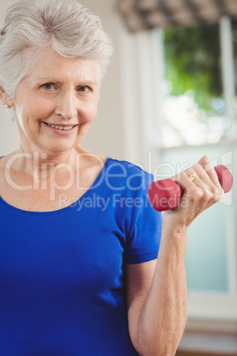 Portrait of senior woman exercising with dumbbells