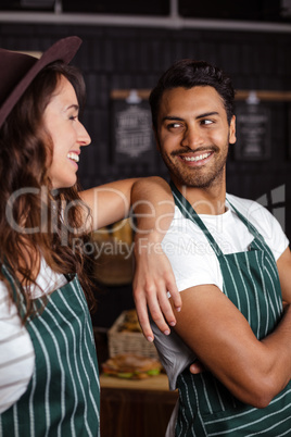 Smiling baristas looking at each other