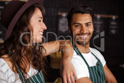 Smiling baristas looking at the camera