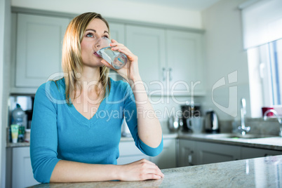 Pretty blonde woman drinking a glass of water