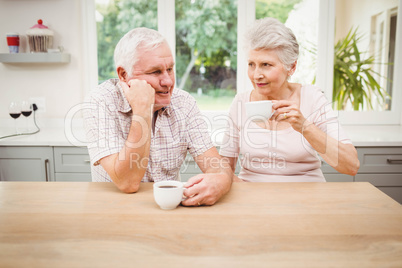 Senior couple talking to each other while having coffee