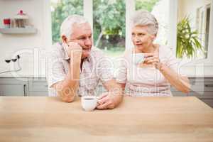 Senior couple talking to each other while having coffee