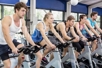 Fit group of people using exercise bike together