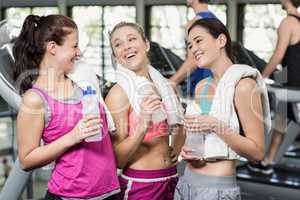 Athletic smiling women posing with bottle of water