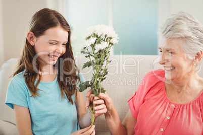 Grandmother giving a bunch of flowers to her granddaughter