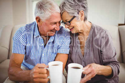 Senior couple having coffee in living room