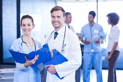 Doctors with medical report looking at camera and smiling