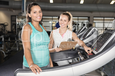Portrait of woman on treadmill and trainer