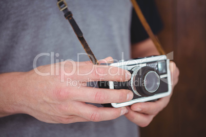 Handsome hipster holding retro camera