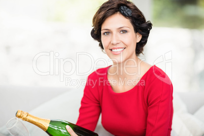 Portrait of beautiful woman holding champagne bottle