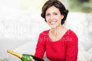 Portrait of beautiful woman holding champagne bottle