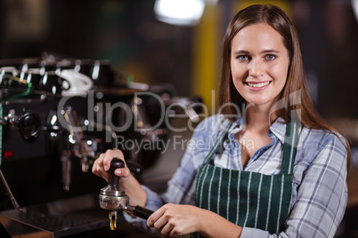 Smiling barista preparing coffee with machine