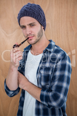 Handsome hipster smocking a pipe