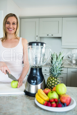 Pretty blonde woman preparing a smoothie