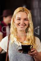 Portrait of smiling pretty customer holding cup of coffee