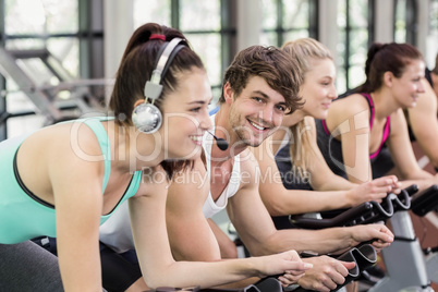 Fit group of people using exercise bike together