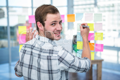 Hipster man writing on post-it