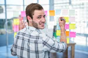 Hipster man writing on post-it