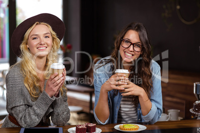 Smiling friends enjoying coffee and pastries