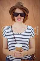 smiling hipster woman holding a take away coffee cup