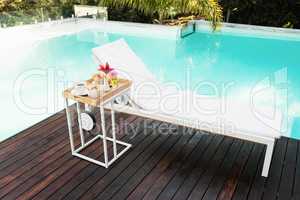 Tray with breakfast in side table and sun lounger