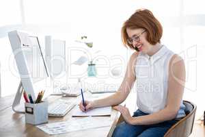 smiling hipster businesswoman sketching at her desk