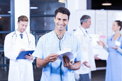 Doctor holding medical report and smiling at camera