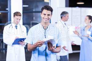 Doctor holding medical report and smiling at camera