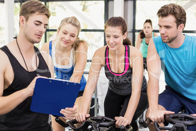 Fit group of people using exercise bike together