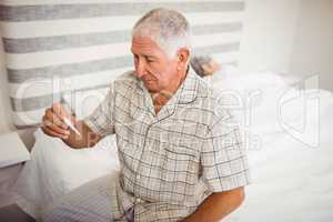 Senior man holding a thermometer