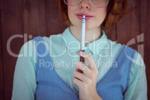 Cute red haired hipster chewing a pen