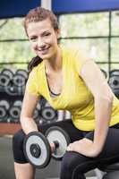 Smiling woman working out with dumbbells