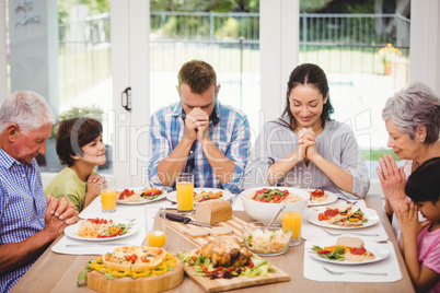 Family praying together before meal
