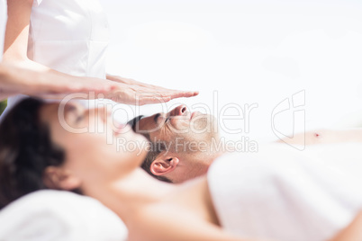 Couple receiving a head massage from masseur