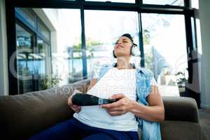 Pregnant woman listening to music on sofa