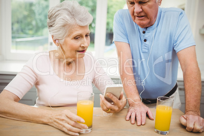 Happy senior couple listening to music