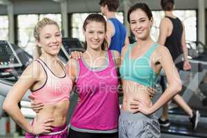 Athletic smiling women posing with hands on hips