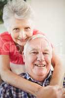 Senior woman embracing man at home